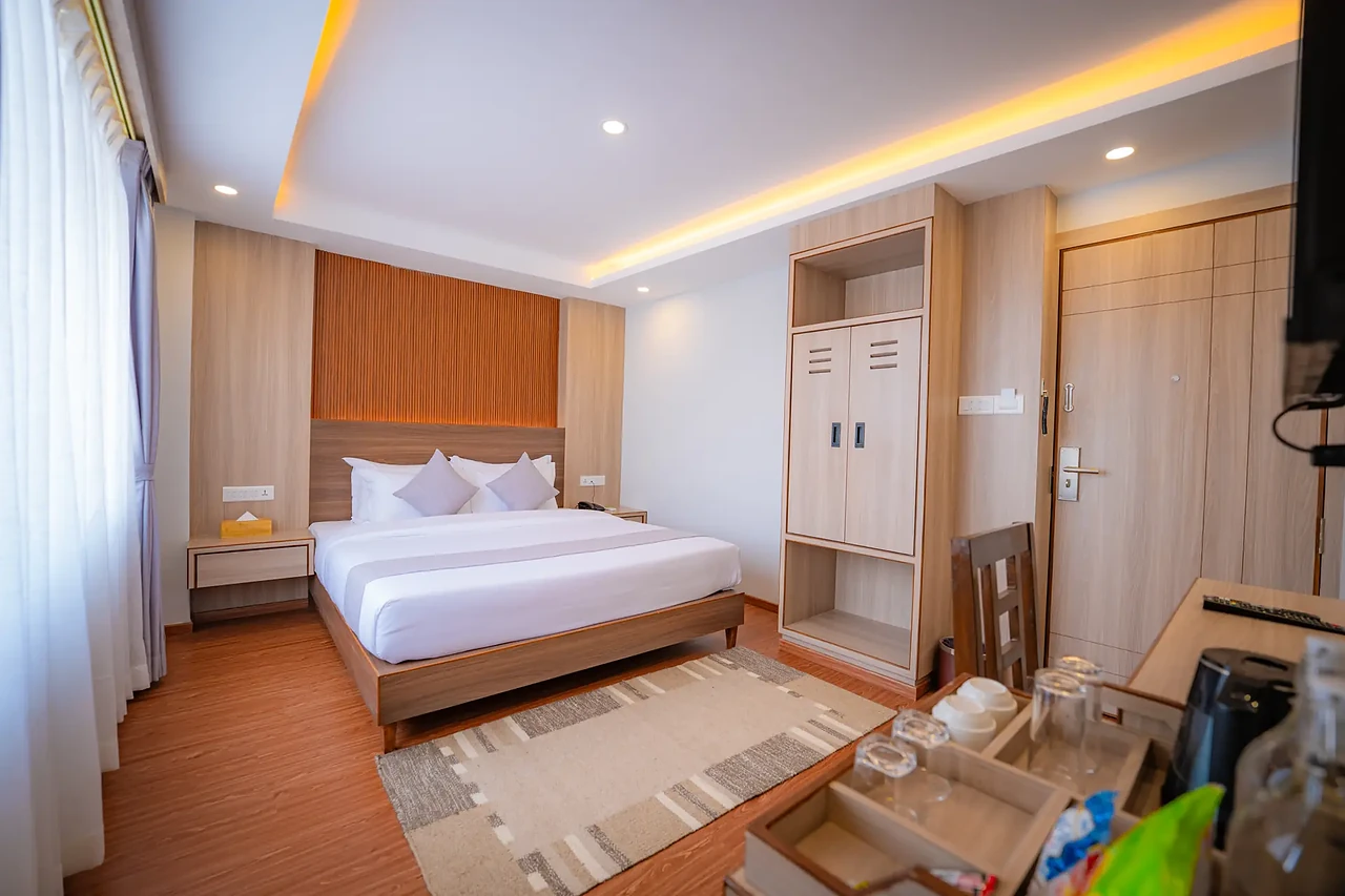 Deluxe guest room at Hotel Sampada with tea tray and wardrobe