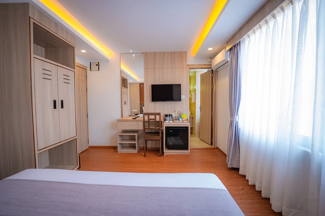 Deluxe Room desk, TV and wardrobe at Hotel Sampada