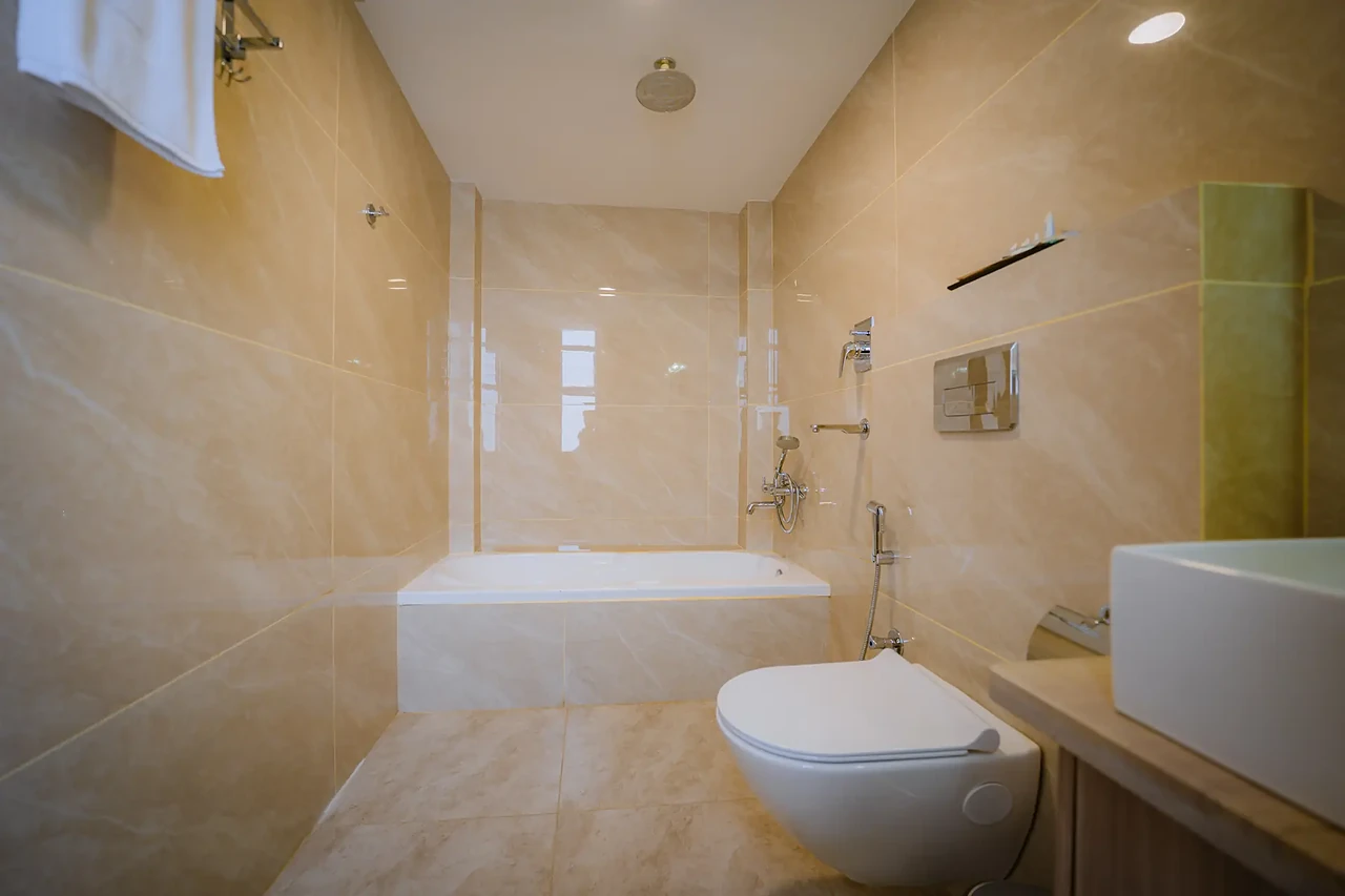 Bathtub and rain shower in a Hotel Sampada bathroom