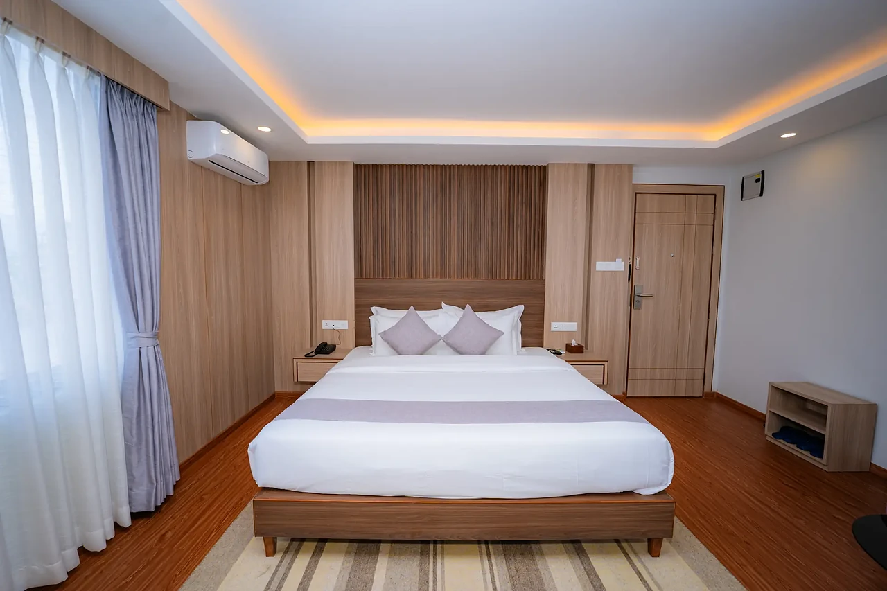 King bed and warm timber wall in a Hotel Sampada suite